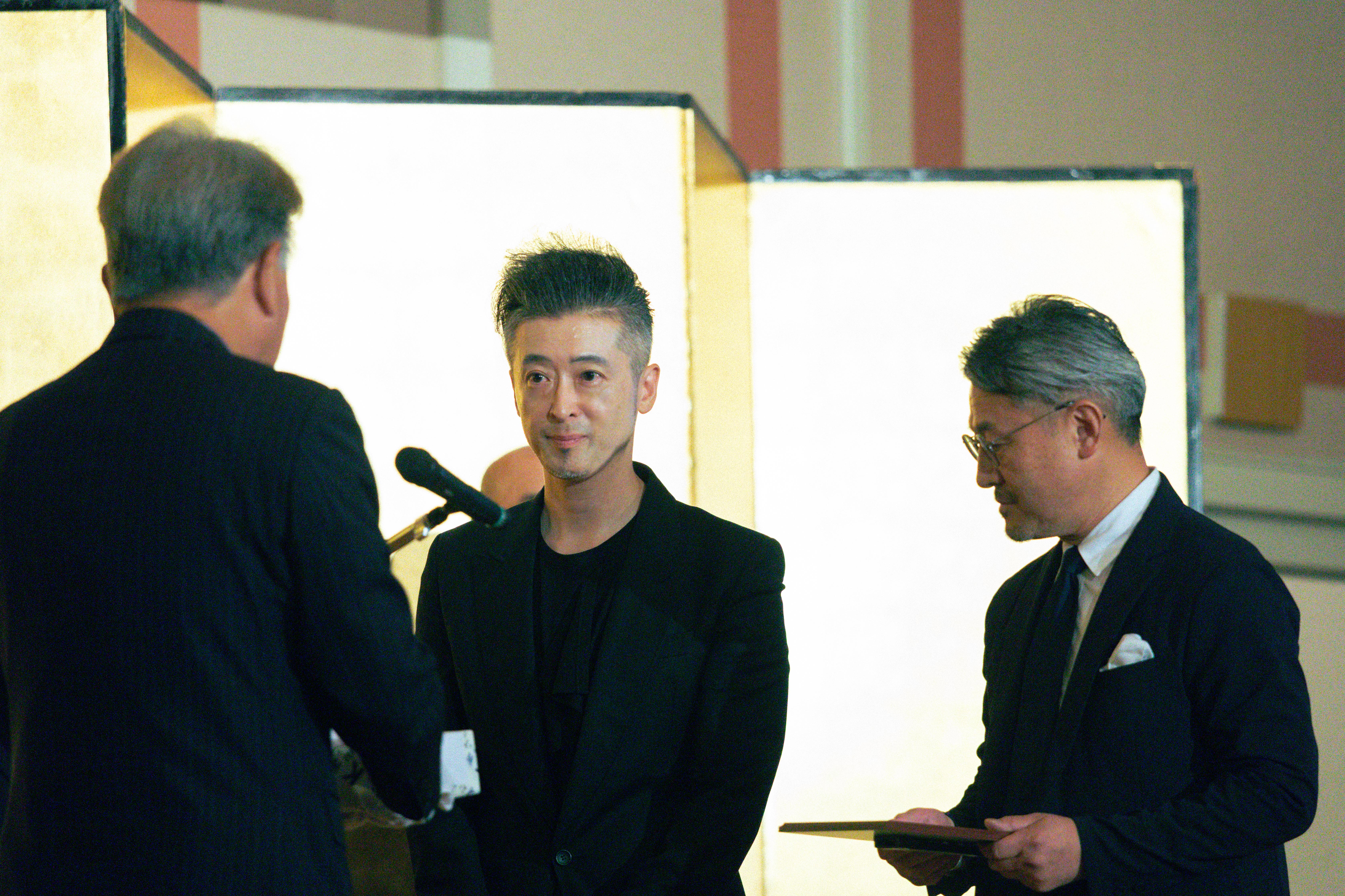 壇上で表彰を受ける中坪久人